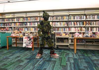 Kid dressed in full costume in front of a shelf of books
