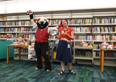 Woman standing next to a person dressed as the mascot Joker Spade.