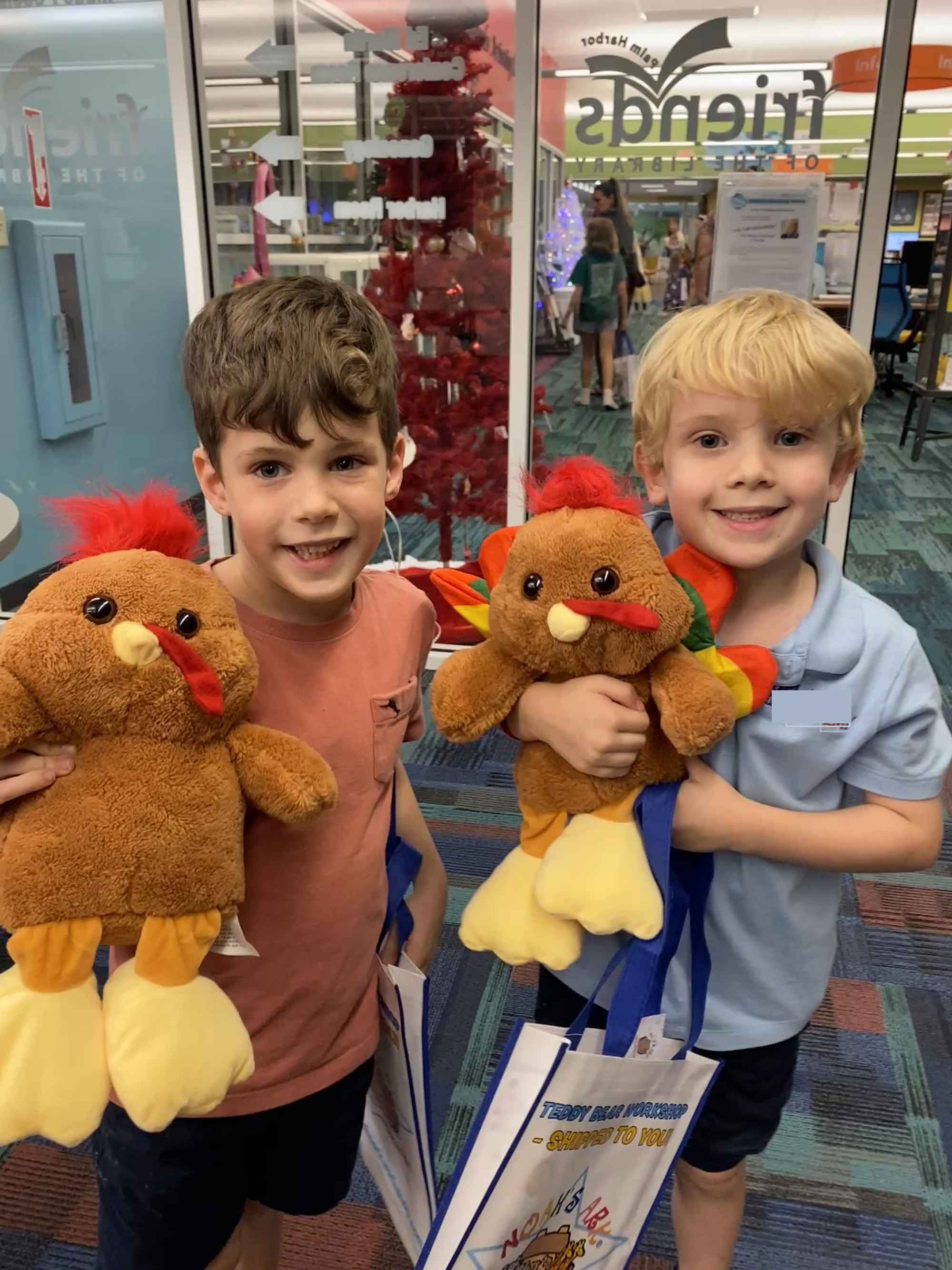 Two Kids holding stuffed turkeys at the library
