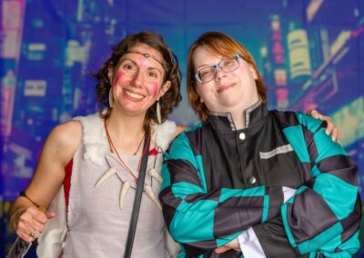 two staff members smiling dressed in costumes